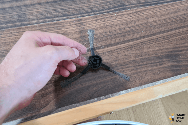 Die Seitenbürste des Dreame L20 Ultra wird von Haaren befreit.